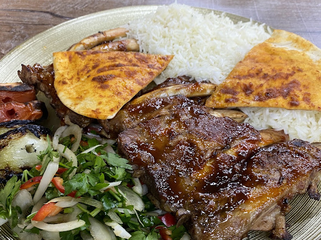 Gegrilde ribs met rijst en salade, foto van een gast